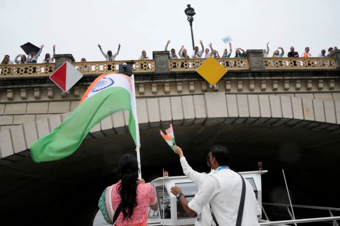 Indian athletes wave from a boat on the Seine River during the opening ceremony of the 2024 Summer Olympic