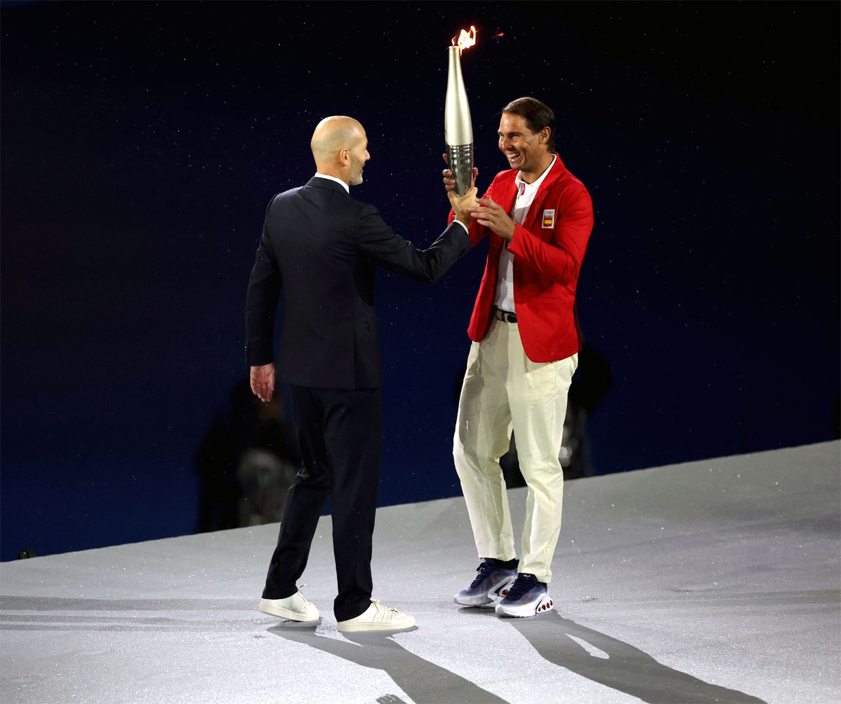 Zinedine Zidane hands over the Olympic torch to Rafael Nadal at the 2024 Paris Olympics opening ceremony on July 26, 2024