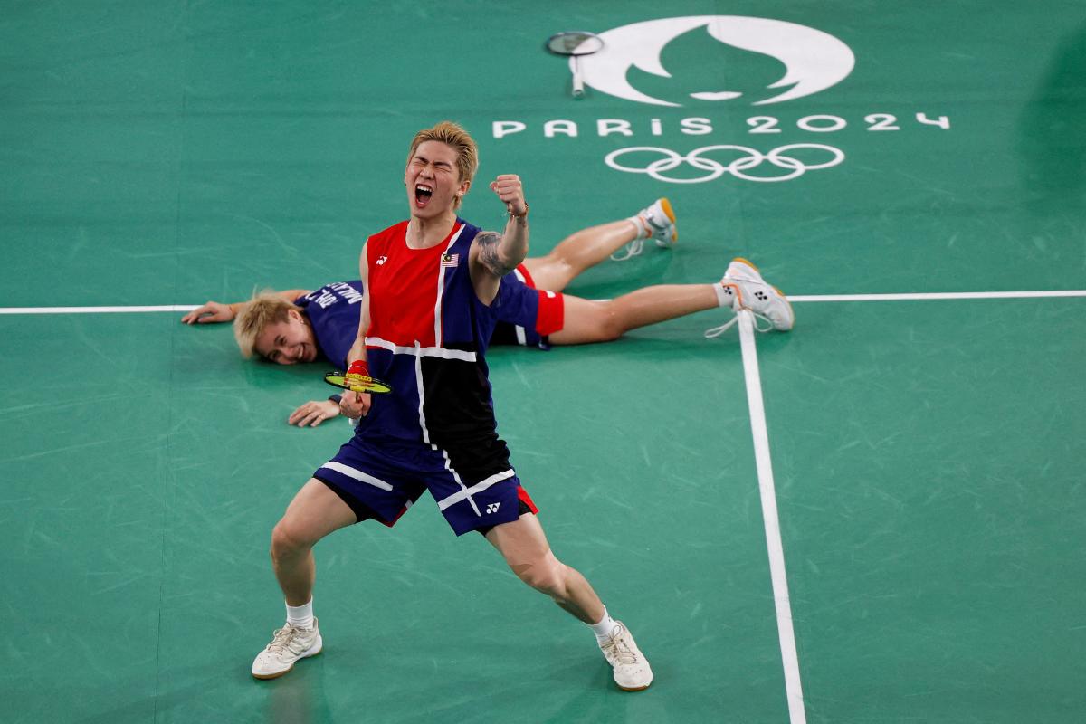 Malaysia's Tang Jie Chen and Ee Wei Toh celebrate after winning the Group D match against China's Yan Zhe Feng of China and Dong Ping Huang during the badminton, mixed goubles group match at Porte de La Chapelle Arena, Paris, France, on Monday