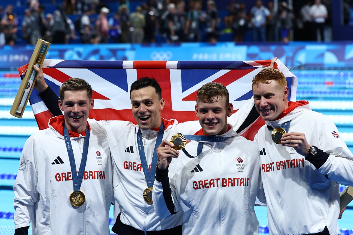Britain's gold medallists James Guy, Tom Dean, Matthew Richards and Duncan Scott celebrate on the podium after the men's 4x200 metres Freestyle relay medal ceremony.