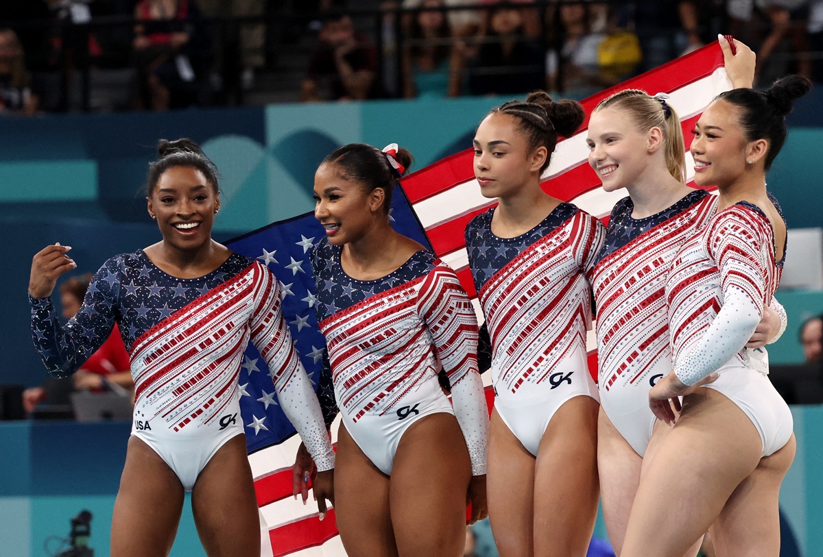 The United States team of Simone Biles, Jordan Chiles, Jade Carey, Sunisa Lee and Hezly Rivera celebrate with their national flag after winning gold in the Olympics Artistic Gymnastics women's Team final at the Bercy Arena, Paris, on Tuesday.