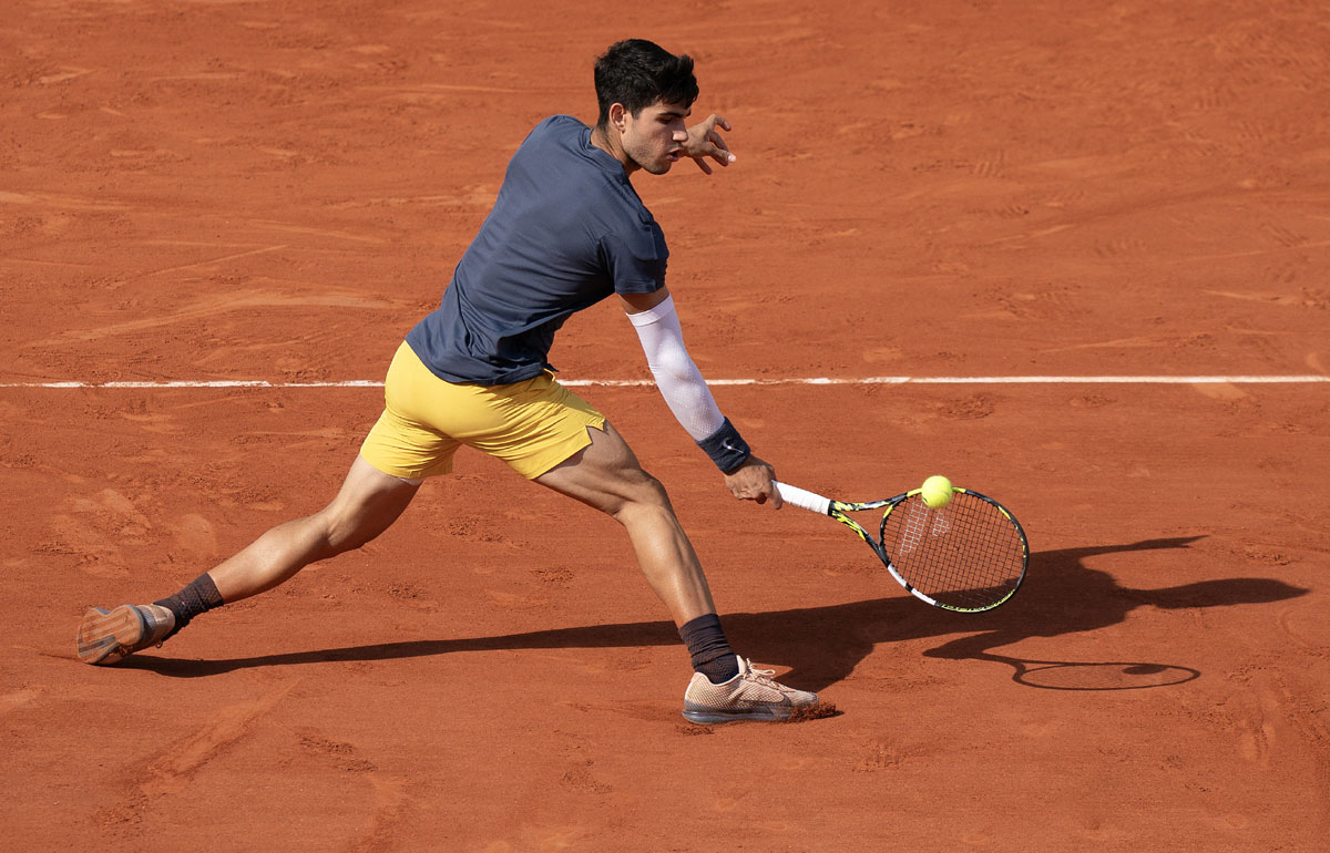 Carlos Alcaraz returns a shot to Alexander Zverev