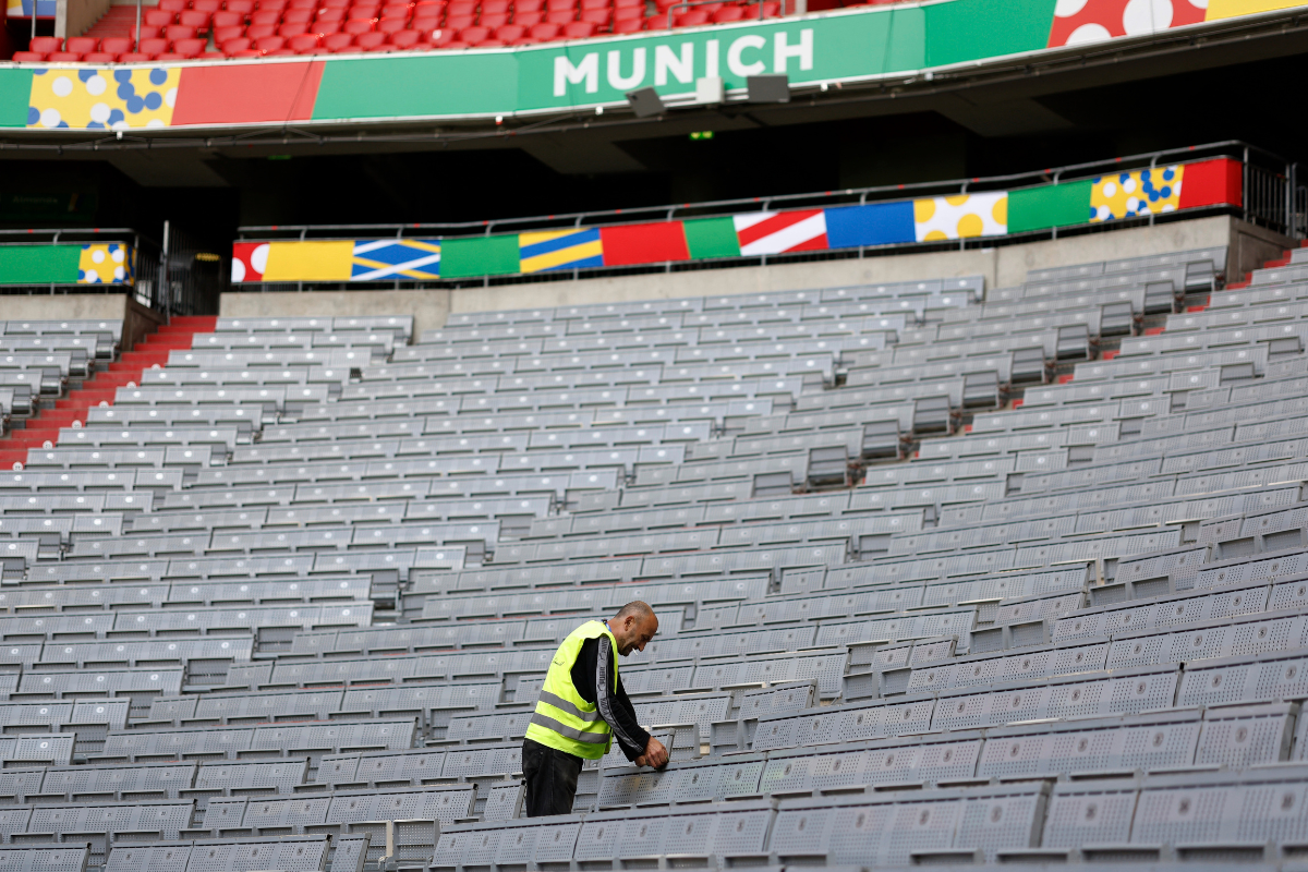 A worker cleans seats inside the stadium at  Munich Football Arena, Munich, Germany, on Wednesday. 