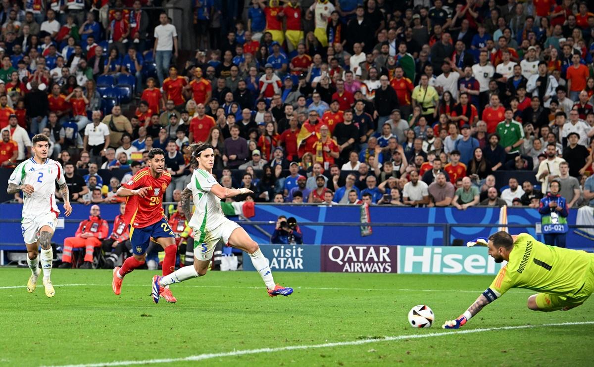 Italy's goalkeeper Gianluigi Donnarumma dives to save a shot from Spain's Ayoze Perez.