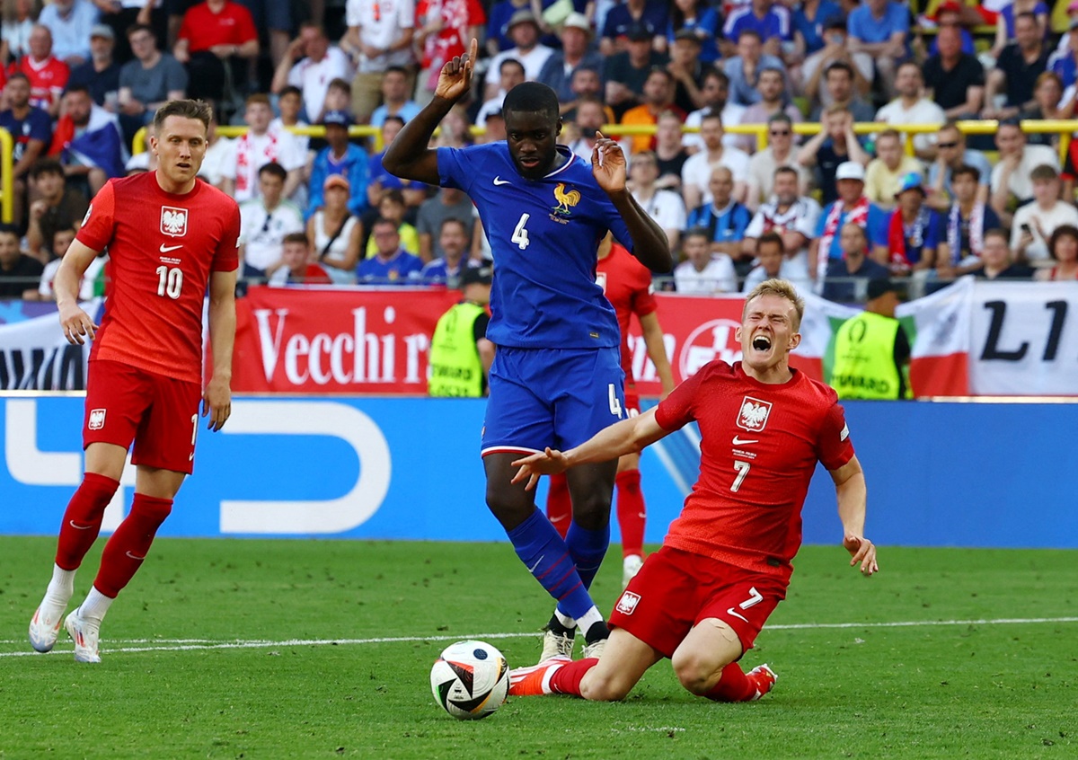 France's Dayot Upamecano brings down Poland's Karol Swiderski and concedes a penalty.