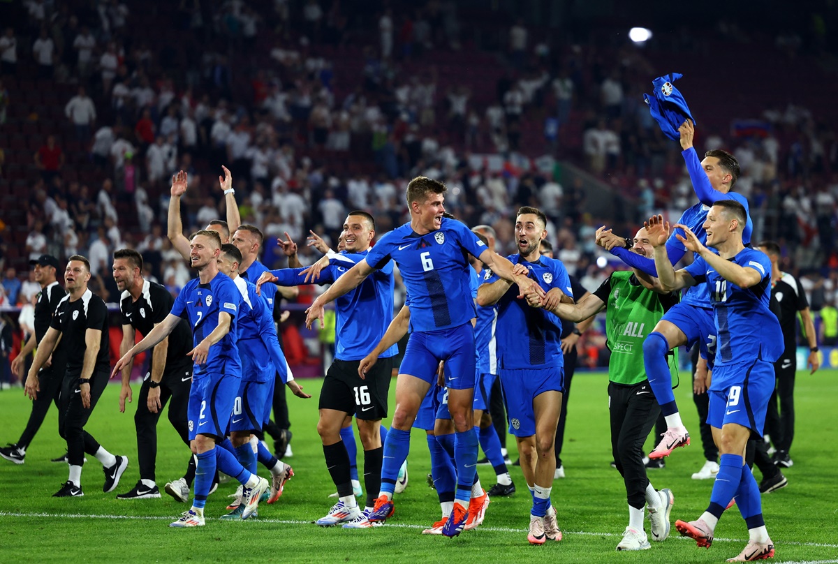 Slovenia's players celebrate after the match, knowing they qualified for the last 16.