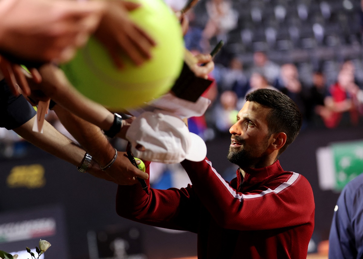 Serbia's Novak Djokovic signs autographs for fans after winning his Italian Open Round of 64 match against France's Corentin Moutet at the Foro Italico, Rome, on Friday.