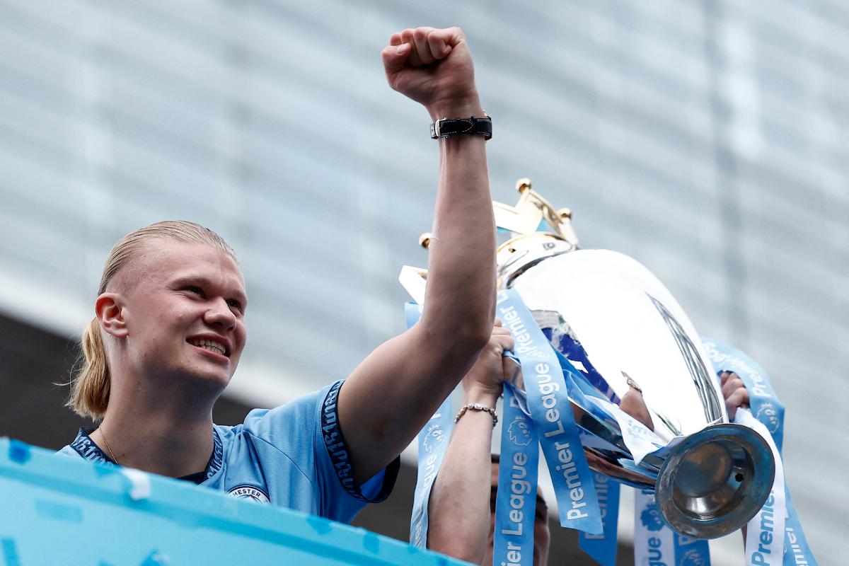 Manchester City's Phil Foden holds the Premier League trophy as Erling Braut Haaland celebrates on the bus during the victory parade in Manchester, Britain, on Sunday 