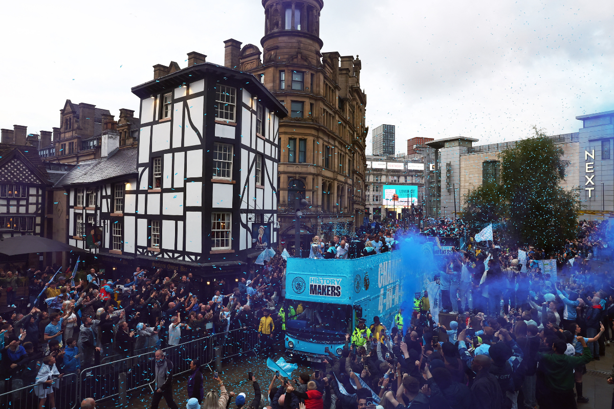 Manchester City players with the Premier League trophy on the bus during the victory parade 