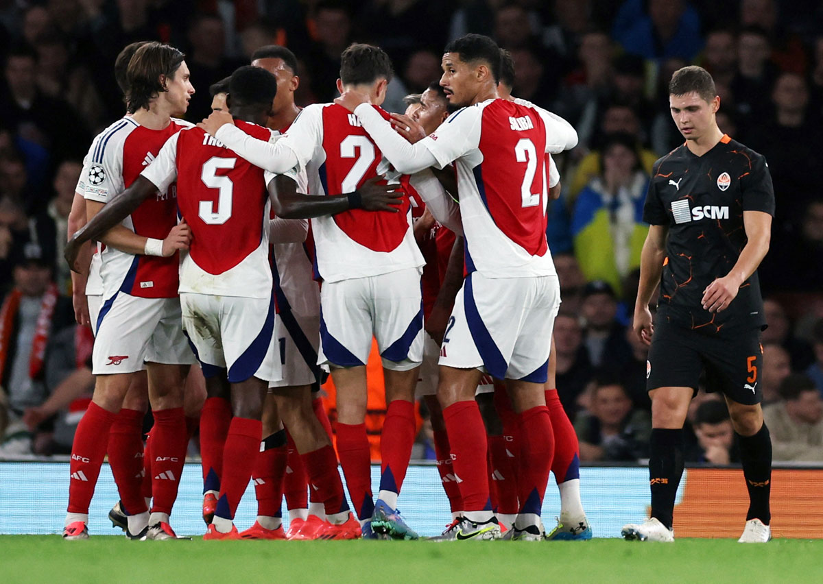 Arsenal's players celebrate after Shakhtar Donetsk's Dmytro Riznyk scored an own goal