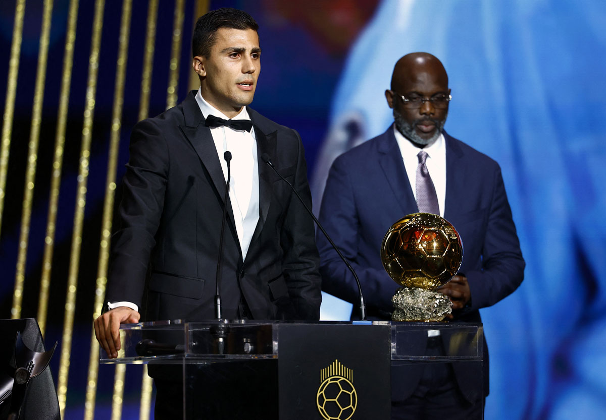 Rodri receives the Ballon d'Or from George Weah