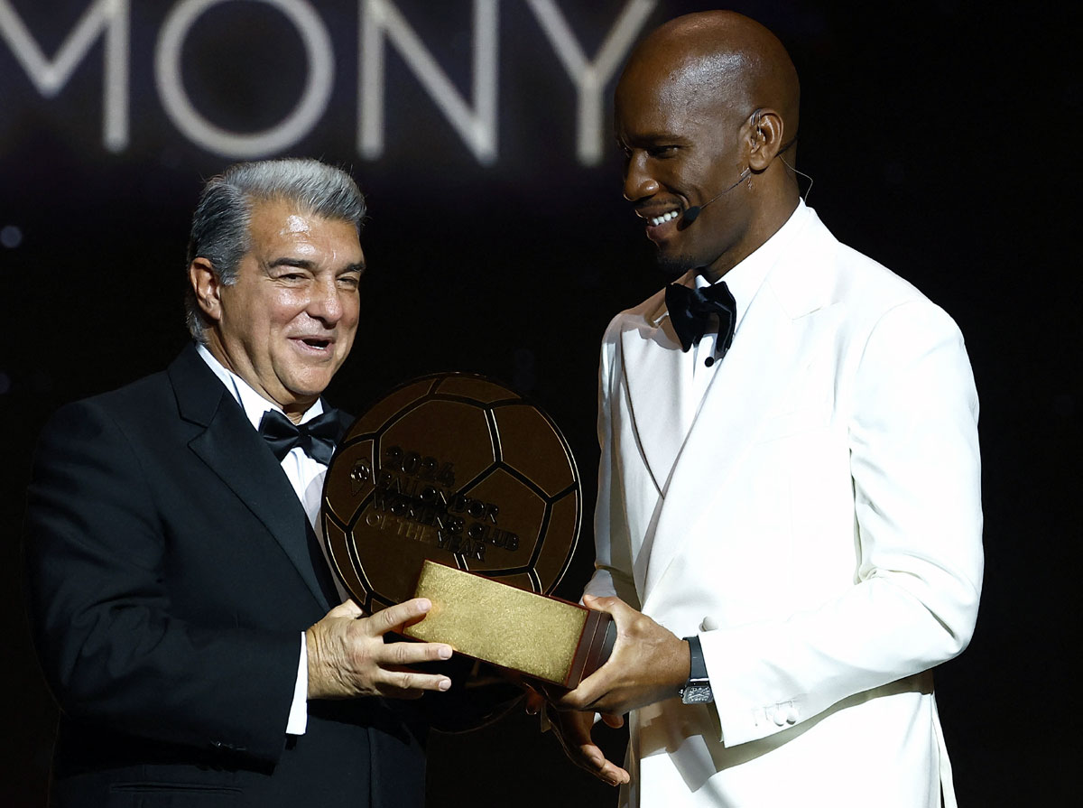 Barcelona president Joan Laporta receives the women's team of the year award from Didier Drogba