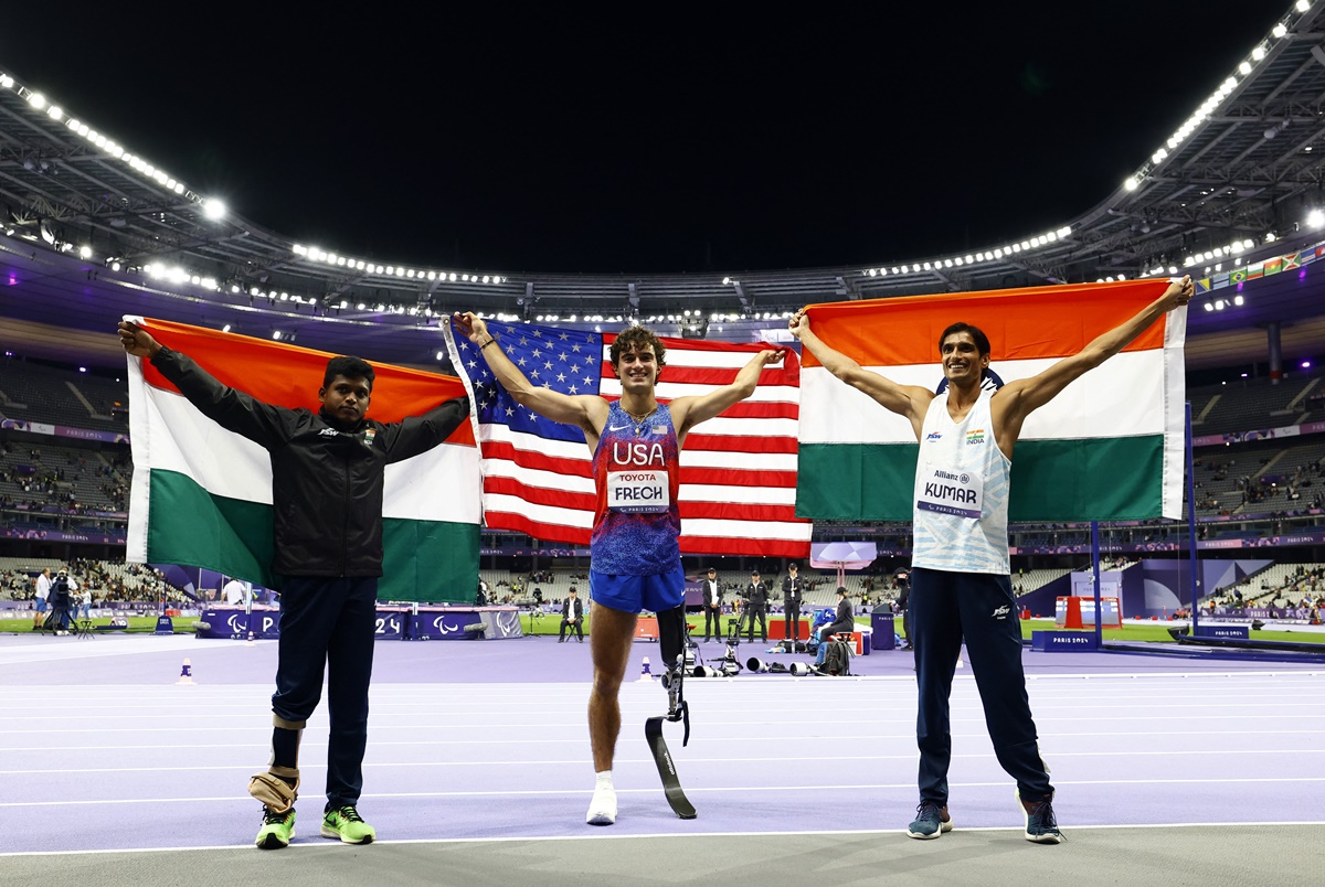 Ezra Frech of the United States celebrates winning gold with India's Sharad Kumar (silver)  and Mariyappan Thangavelu (bronze).