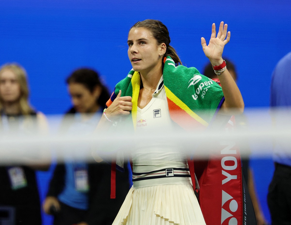 A dejected Emma Navarro waves to the crowd as she walks off the court.