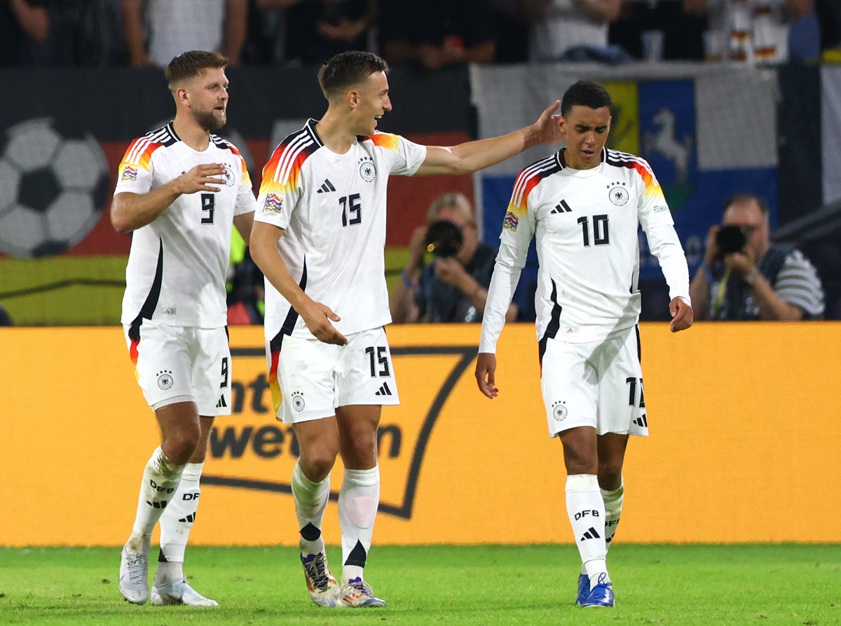 Jamal Musiala is congratulated by Nico Schlotterbeck and Niclas Fullkrug after scoring Germany's second goal.