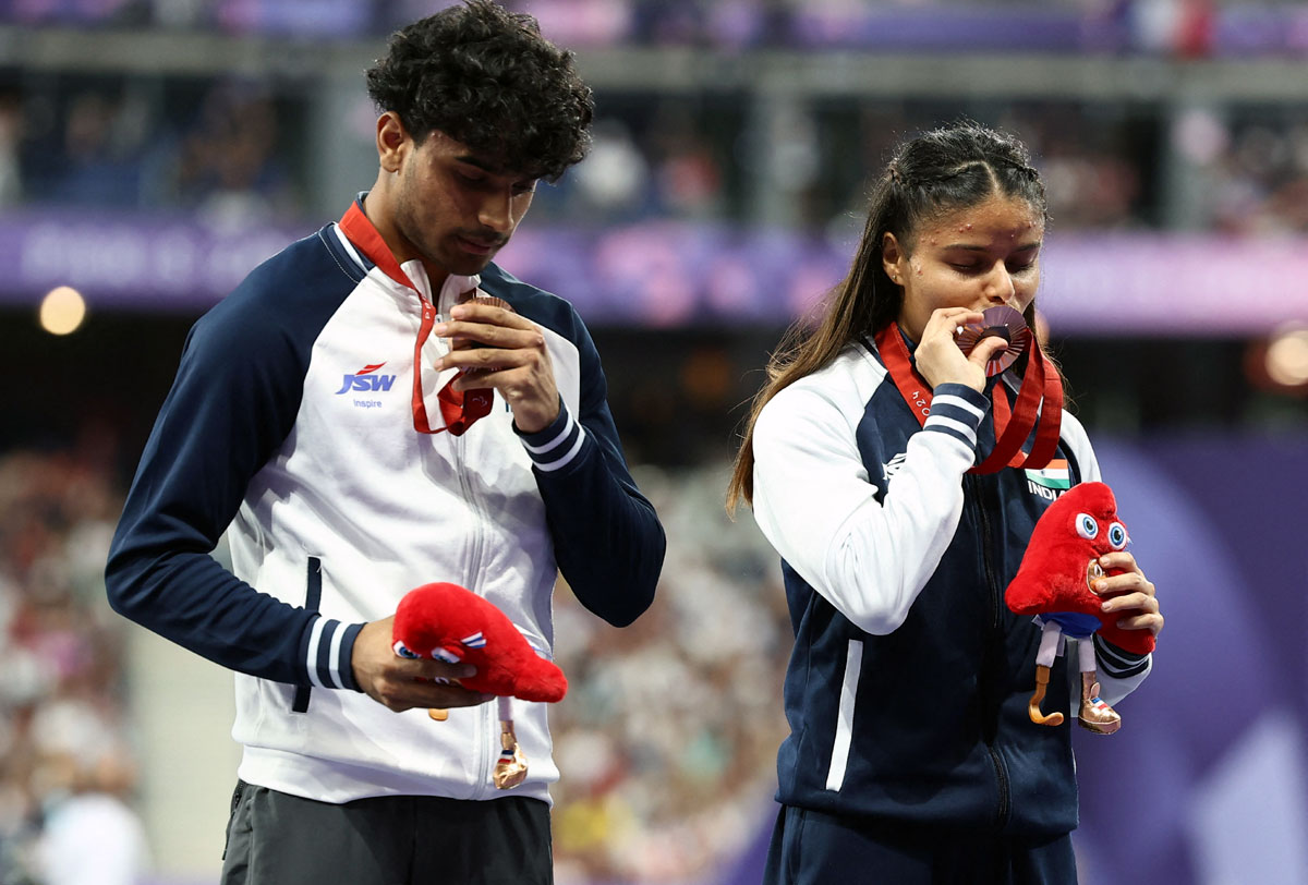 Bronze medallists Simran of India and guide Abhay Singh celebrate on the podium