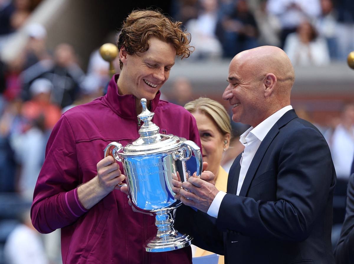 Former tennis player Andre Agassi presents the trophy to Italy's Jannik Sinner