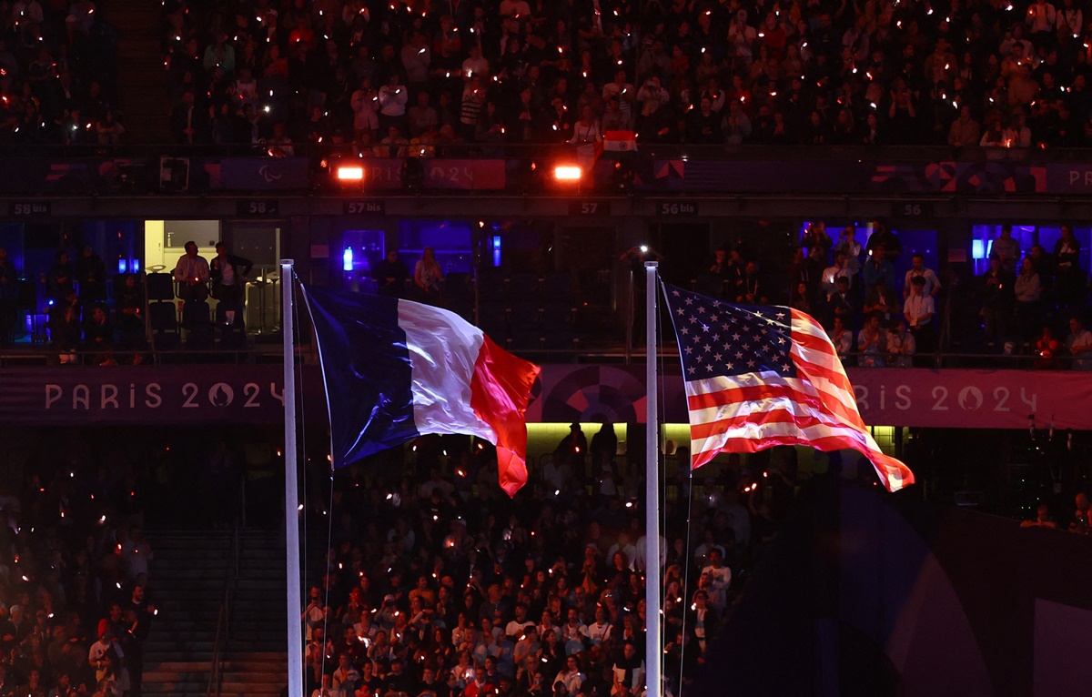 The flags of hosts France and the United States, which will host the next Games at Los Angeles in 2028, are hoisted during the closing ceremony.