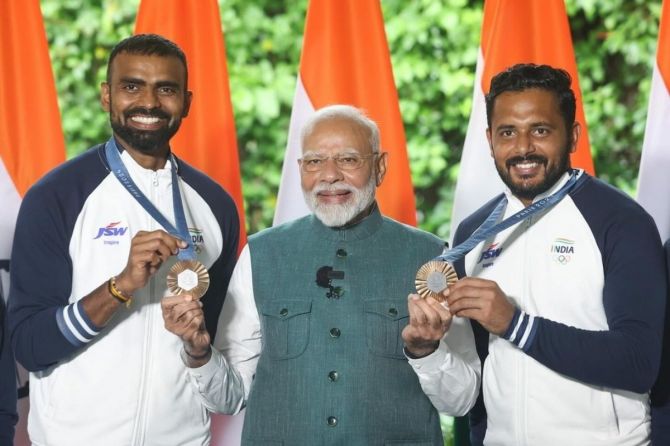 PR Sreejesh and  Harmanpreet Singh with Prime Minister Narendra Modi after their return from the Paris Olympics