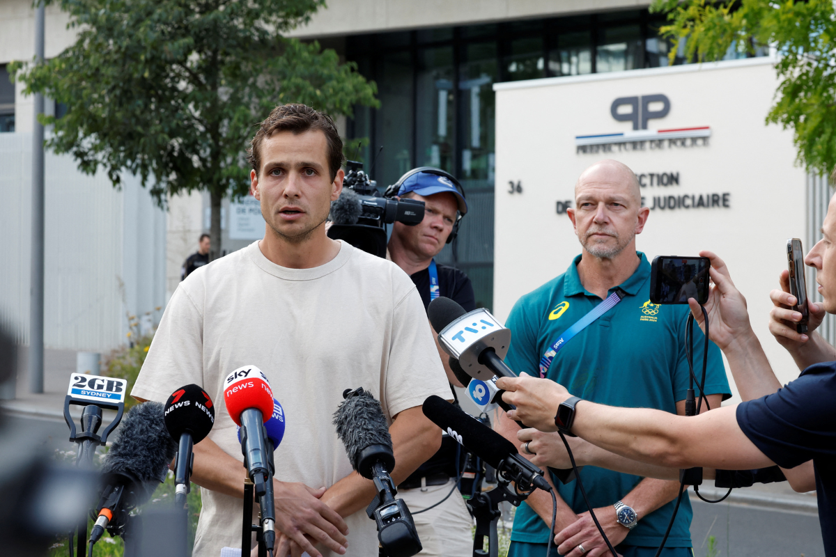 Australian Olympic hockey player Thomas Craig speaks to the media alongside Hockey Australia's High Performance Director Bernard Savage outside the headquarters of the judiciary police in Paris, France, August 7