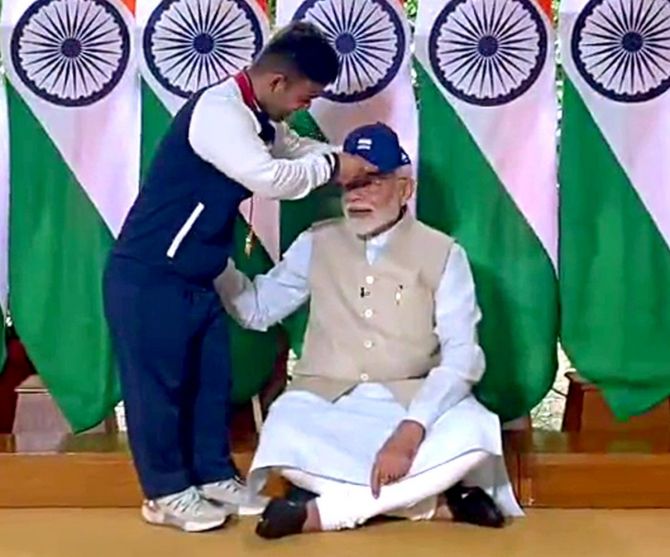 Paralympic gold medallist Navdeep Singh presents PM Narendra Modi with a cap