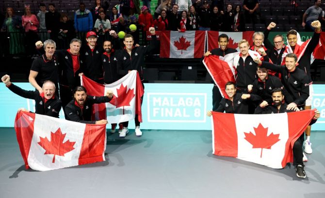 Canada players celebrate with their national flags after winning against Britain