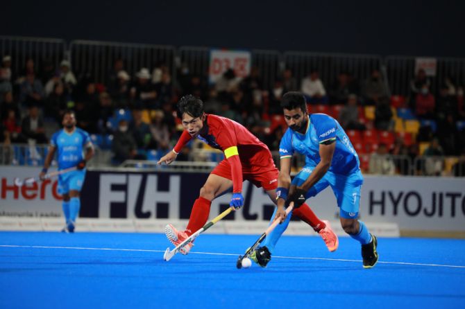 Manpreet Singh wins possession and beats his South Korean opponent to race away with the ball