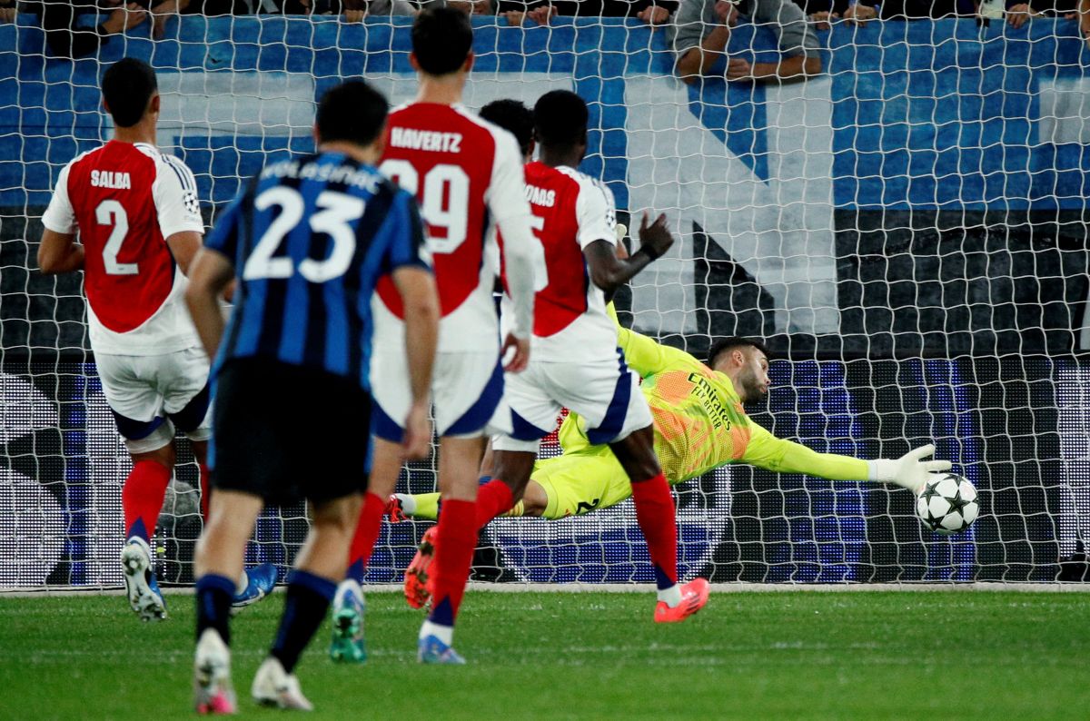 Arsenal goalkeeper David Raya saves the rebound from Atalanta's Mateo Retegui after saving a penalty