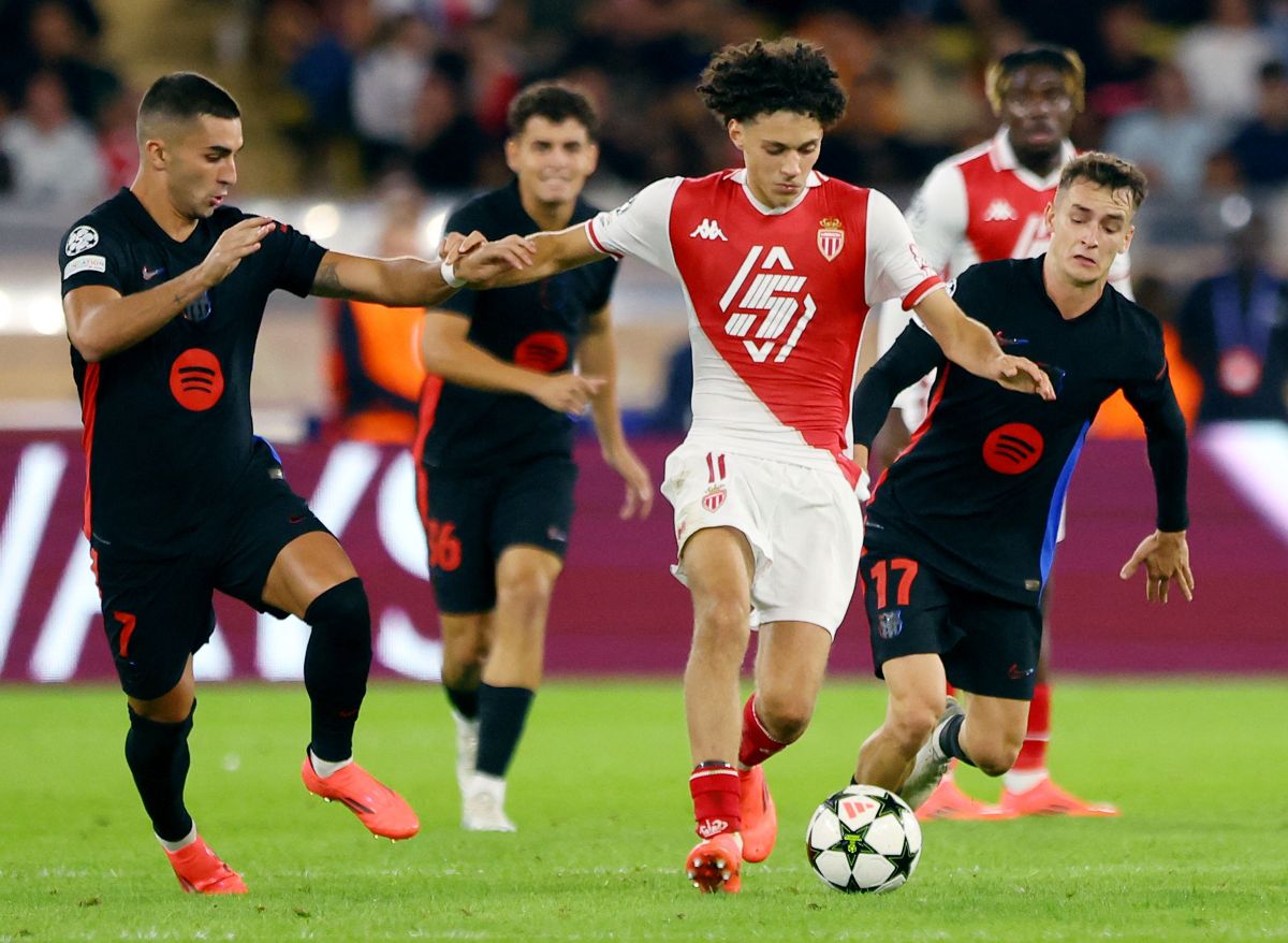 AS Monaco's Maghnes Akliouche tries to get the ball past Ferran Torres and Marc Casado of Barcelona