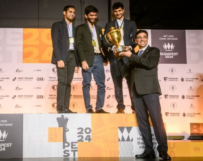 Viswanathan Anand presents the trophy to Arjun Erigaisi, Dommaraju Gukesh and Vidith Gujrathi