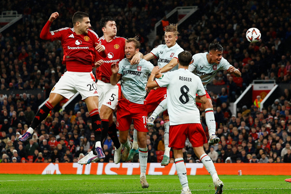 Manchester United's Diogo Dalot and Harry Maguire are airborne as they vie for an aerial ball with FC Twente's Michel Vlap and Max Bruns during their Europa League match at Old Trafford. 