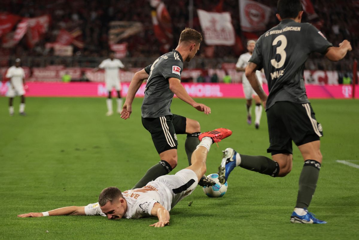 Bayer Leverkusen's Florian Wirtz is tackled by Bayern Munich's Joshua Kimmich