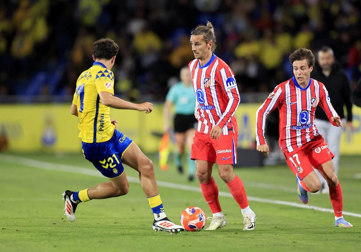 Atletico Madrid's Antoine Griezmann and Rodrigo Riquelme are challenged by Las Palmas's Stefan Bajcetic.