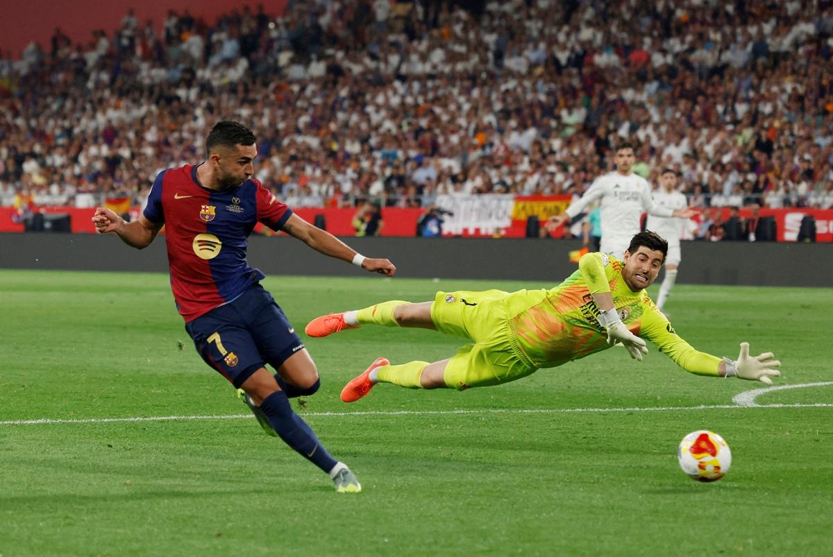 Ferran Torres sends the ball past Real Madrid's Thibaut Courtois for Barcelona's second goal.