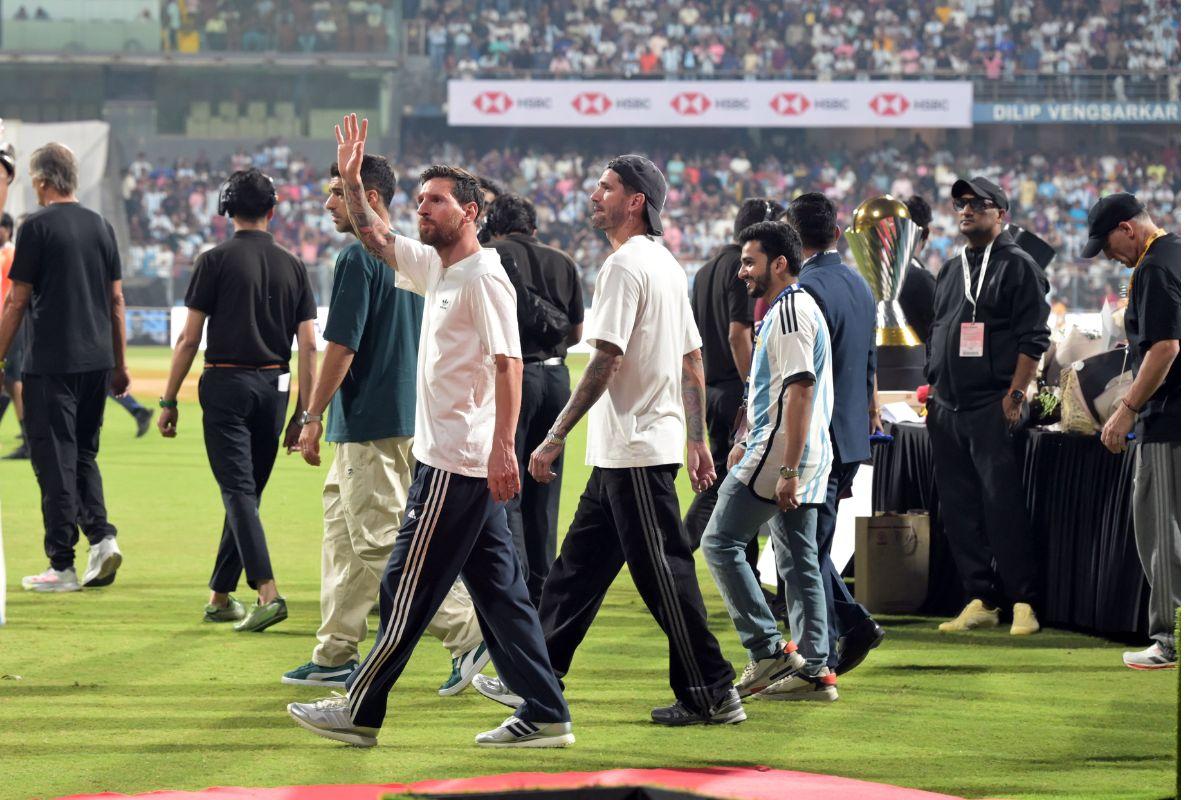 Lionel Messi waves to the fans as he takes a lap across the stadium