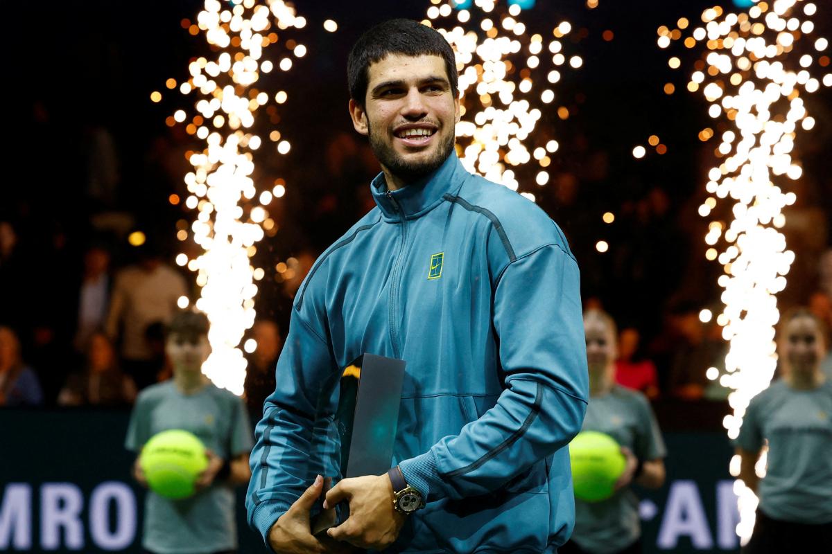 Spain's Carlos Alcaraz celebrates with the trophy after beating Australia's Alex de Minaur to win the Rotterdam Open on Sunday