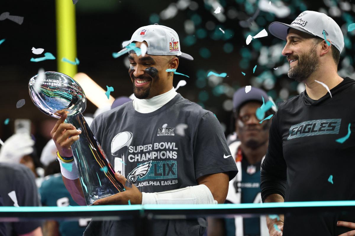 Philadelphia Eagles quarterback Jalen Hurts (1) holds the Vince Lombardi Trophy as Philadelphia Eagles head coach Nick Sirianni looks on after defeating the Kansas City Chiefs in Super Bowl LIX at Ceasars Superdome in New Orleans on Sunday