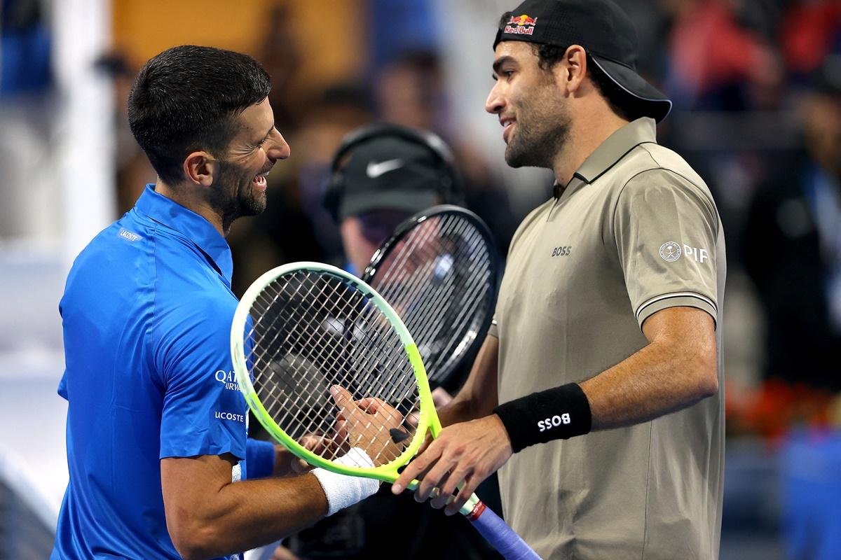 Matteo Berrettini is congratulated by Novak Djokovic after the match.