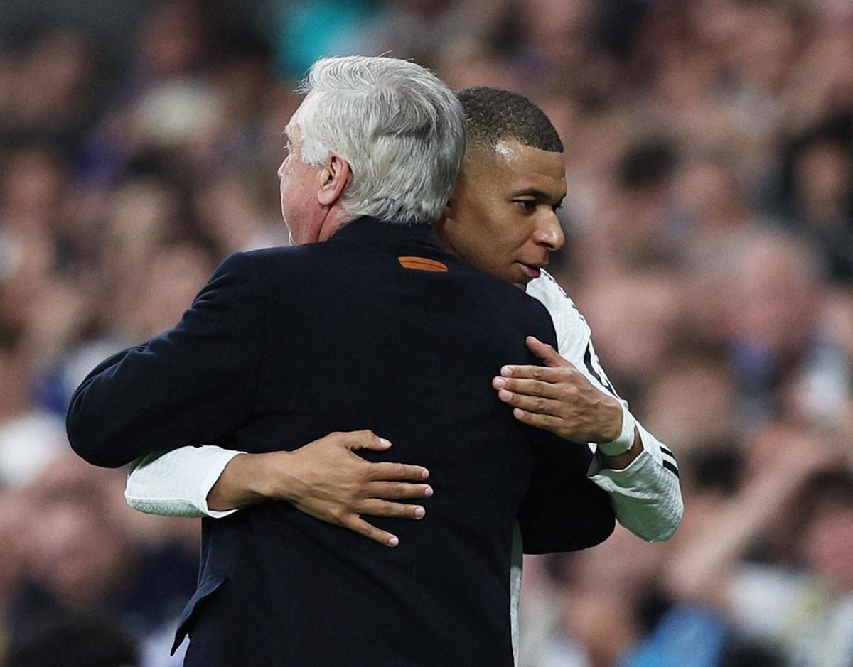 Kylian Mbappe gets a hug from Real Madrid coach Carlo Ancelotti after being substituted during the match.