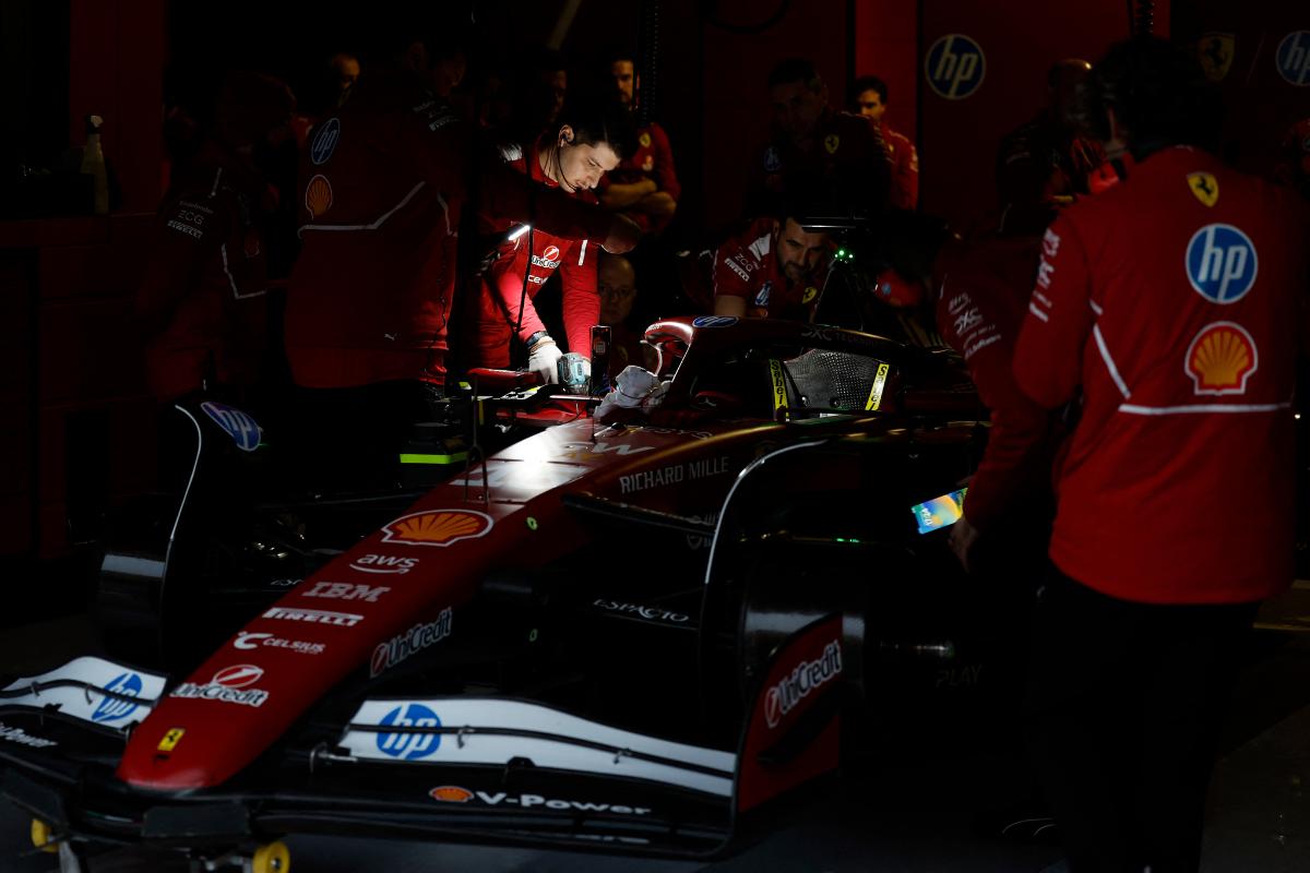 Ferrari mechanics use torches during a power cut as they work on Ferrari's Charles Leclerc's car during testing at the pre-season testing at the Bahrain International Circuit, Sakhir, Bahrain, on Wednesday