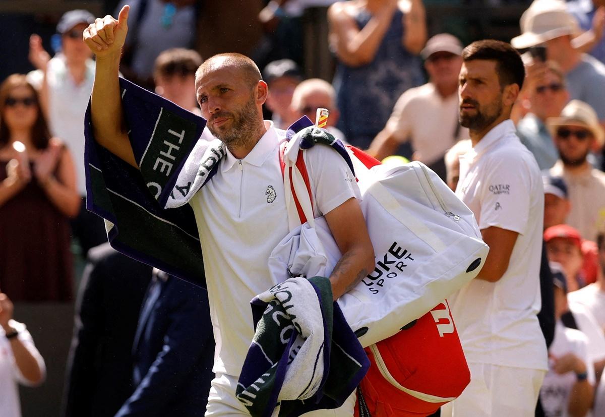 Daniel Evans waves to the fans as he walks back after his second round match against Novak Djokovic.