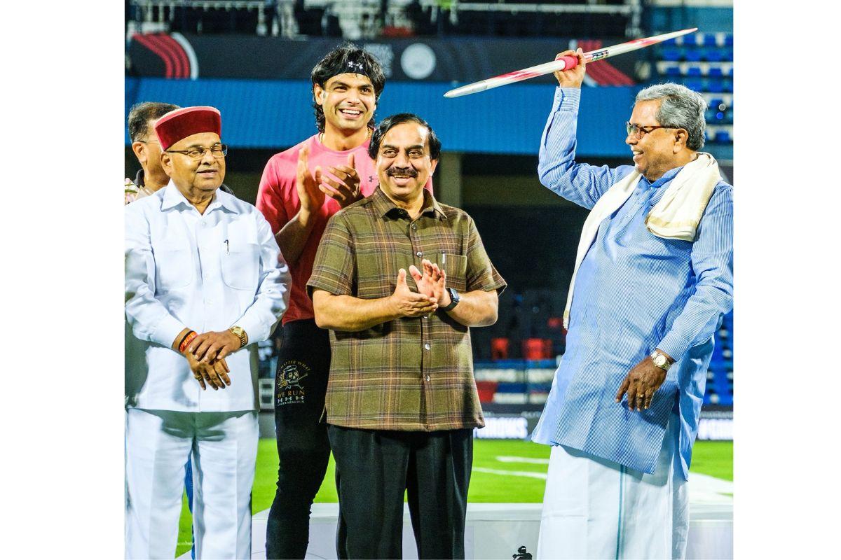Karnataka Chief Minister Siddaramaiah with a javelin as Neeraj Chopra smiles in the background on Satiurday 