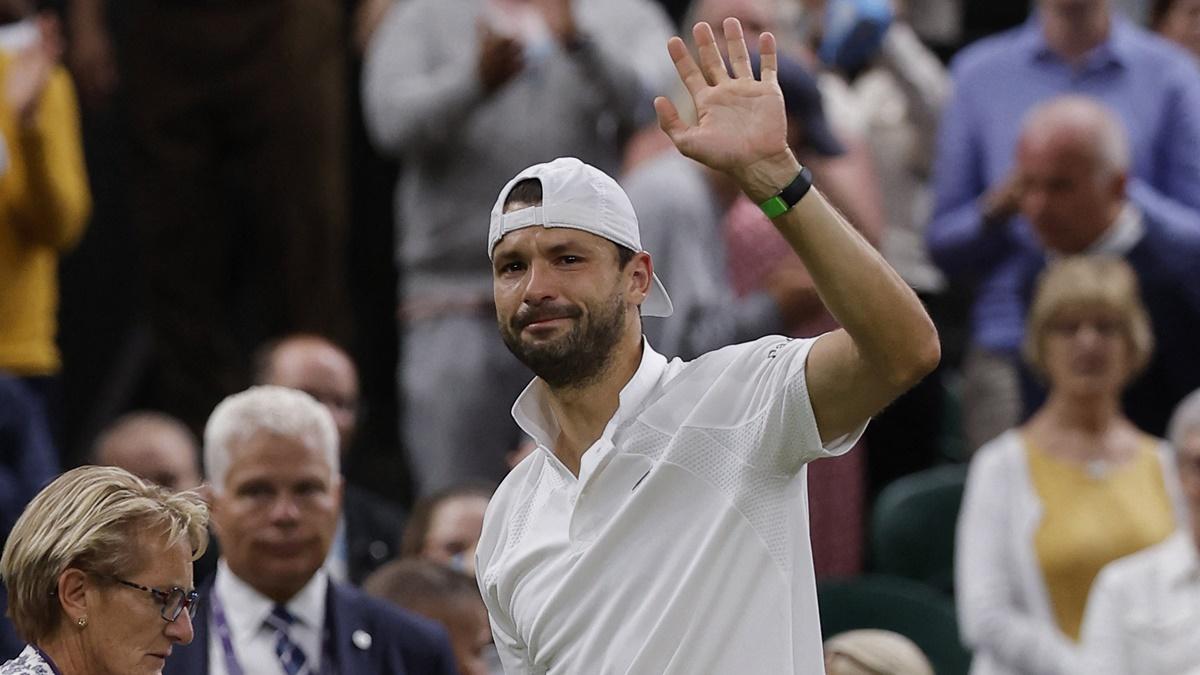 Grigor Dimitrov waves to the crowd as he walks off the court after retiring injured.
