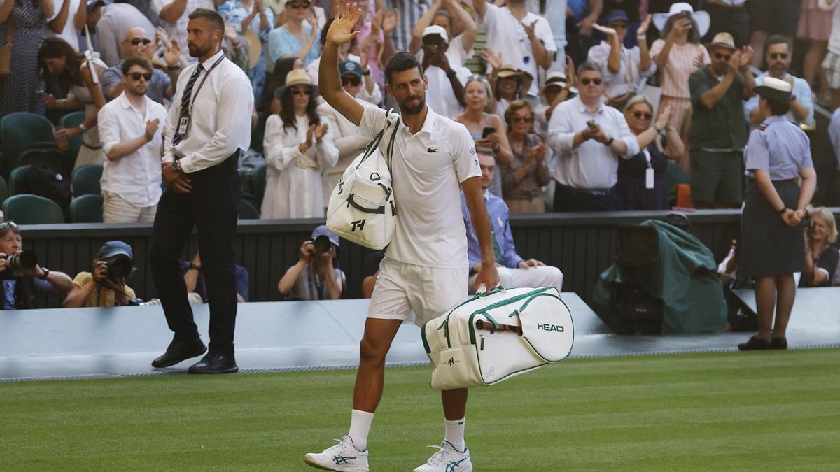 Novak Djokovic waves to the crowd as he walks off the court.