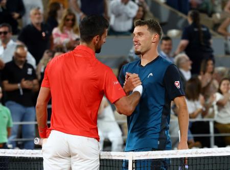 Novak Djokovic shakes hands with Filip Misolic after their third round match.