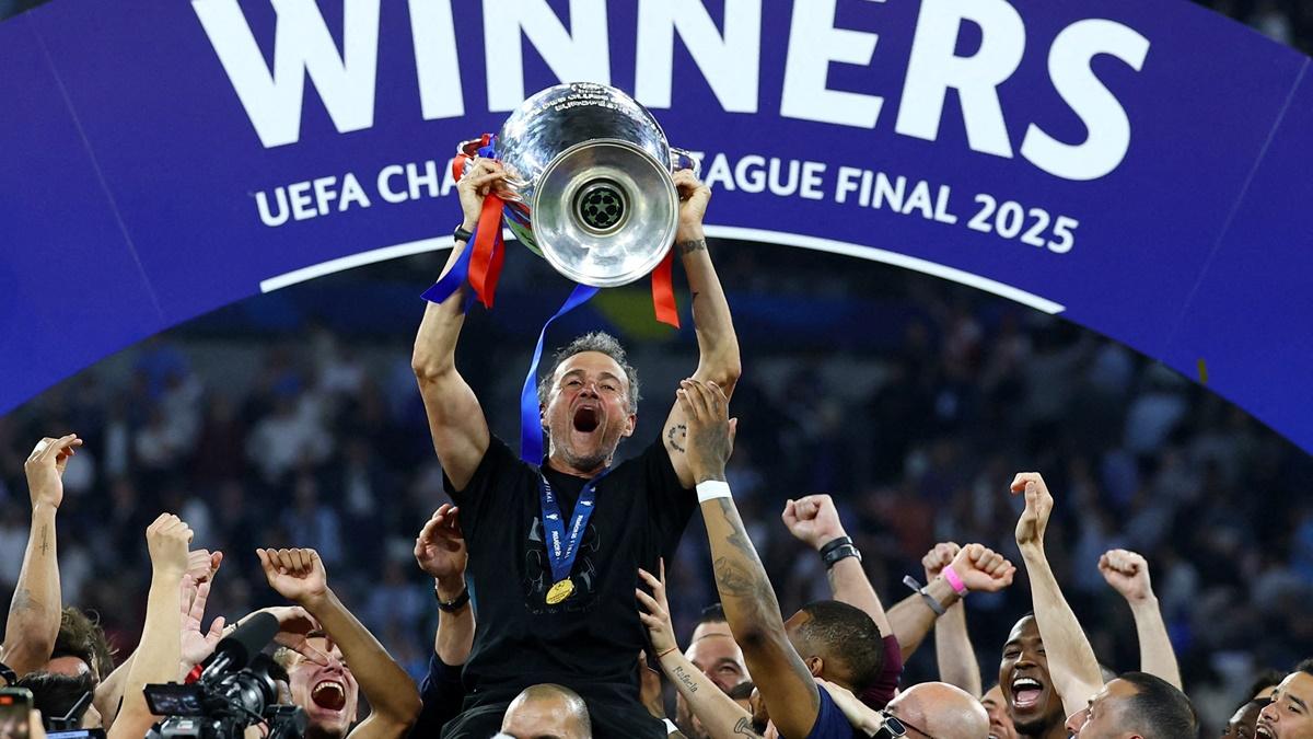 Paris St Germain coach Luis Enrique hoists the trophy as he celebrates with his players after victory over Inter Milan in the Champions League final at Allianz Arena, Munich, Germany, on Saturday.