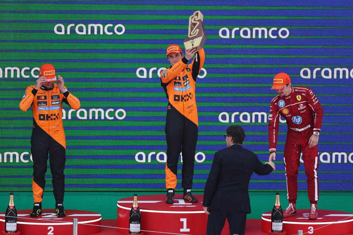 McLaren's Oscar Piastri celebrates with a trophy after winning the Spanish Grand Prix with second placed McLaren's Lando Norris and third placed Ferrari's Charles Leclerc on the podium