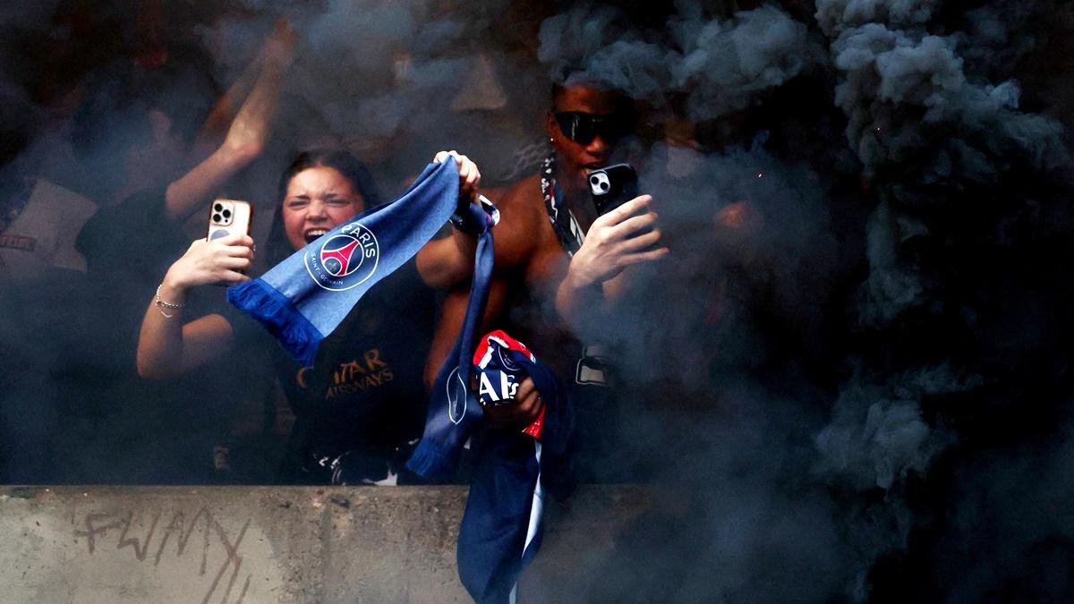 Paris St Germain fans at the Parc des Princes celebrate after Desire Doue scores their second goal.