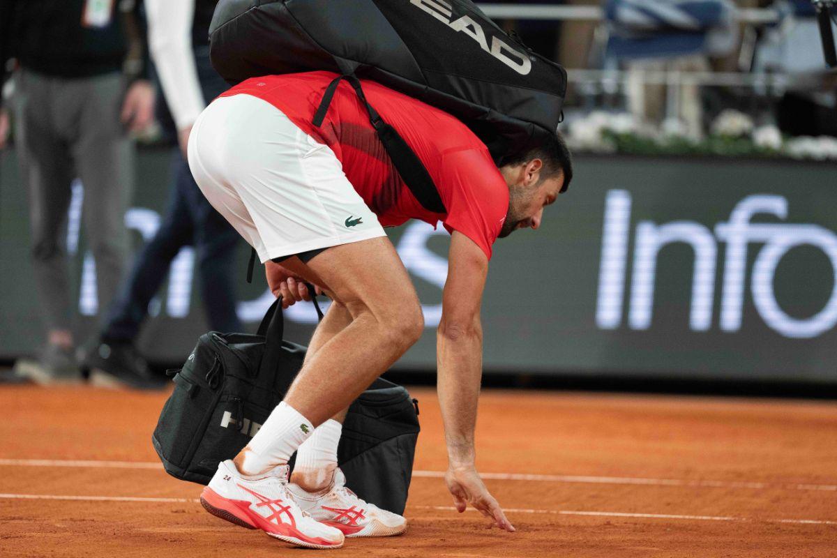 Serbian Novak Djokovic kisses the clay as he leaves the court after his loss to Jannik Sinner of Italy at Roland Garros in Paris on Friday