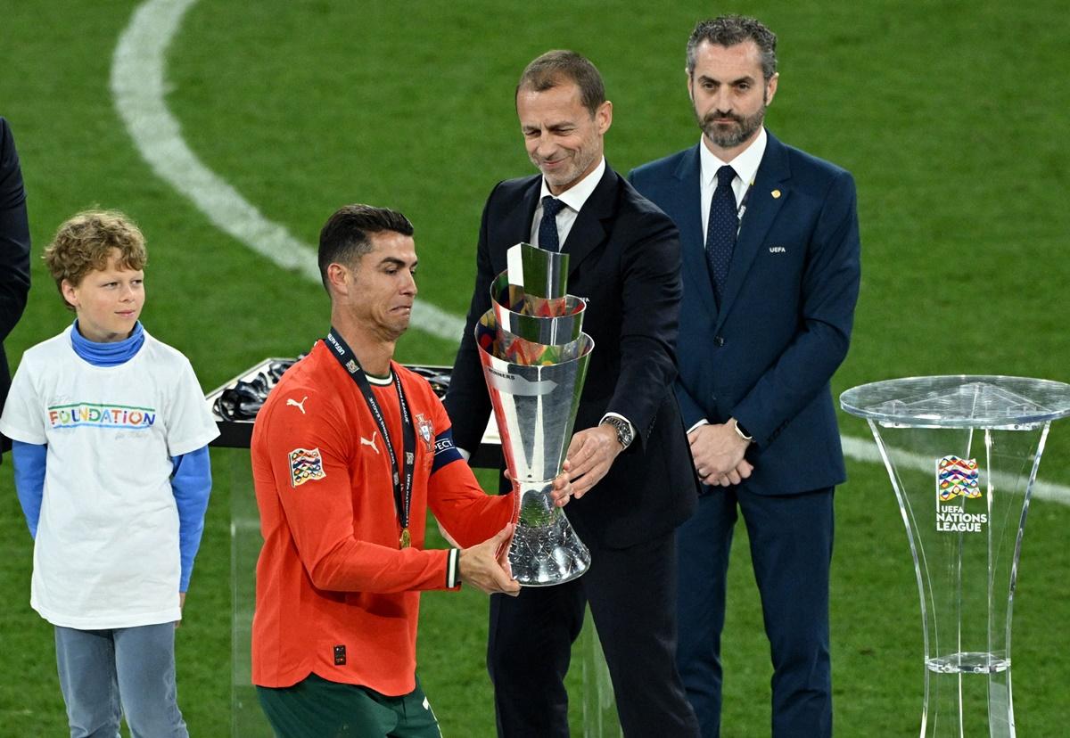 Cristiano Ronaldo receives the Nations League trophy from UEFA president Aleksander Ceferin.